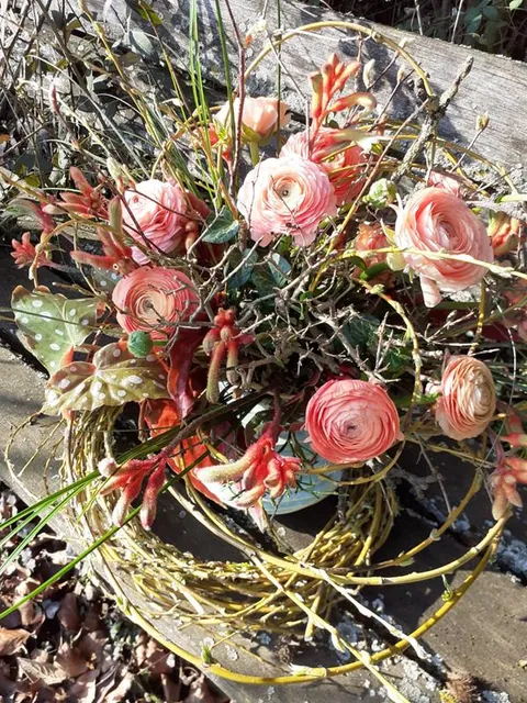 Frühlingsgesteck mit rosa Ranunkeln, Weidenkätzchen und Zweigen