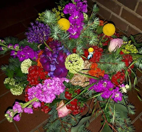 Strauß mit violetten Levkojen, roten Ranunkeln und Billy Buttons