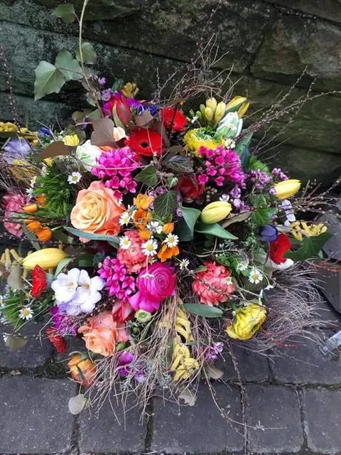Wilder bunter Strauß mit Rosen, Tulpen und Gräsern